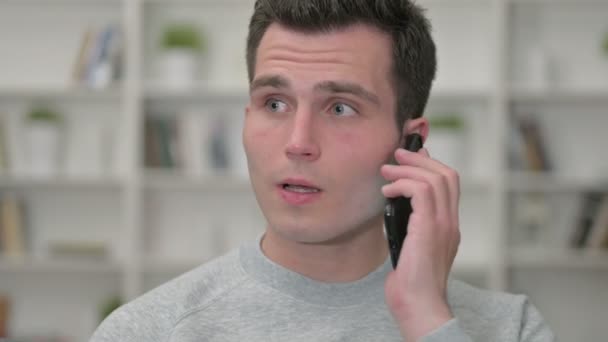 Retrato de alegre joven diseñador masculino que habla en el teléfono inteligente — Vídeo de stock