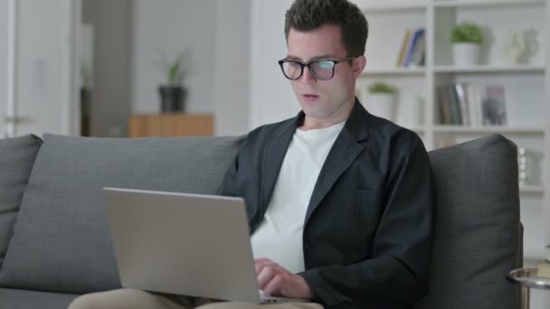 Stres mladý muž designér s notebookem s bolestí hlavy doma — Stock video