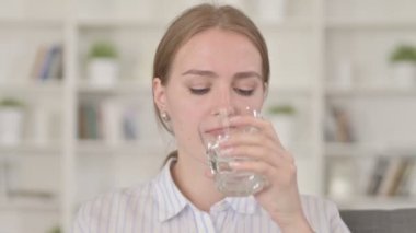 Soğuk su içerken dişi ağrıyan genç bir kadın. 