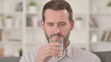 Soğuk su içerken diş ağrısı çeken bir adam. 