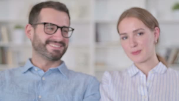 Retrato de feliz pareja joven mostrando el signo del corazón con las manos — Vídeos de Stock