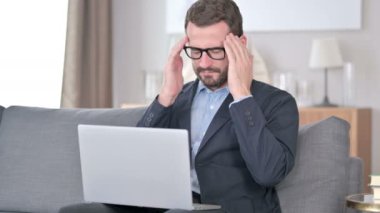 Laptop 'u olan genç iş adamı evinde baş ağrısı çekiyor. 