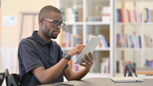 专业的非洲年轻人在图书馆使用平板电脑 — 图库视频影像