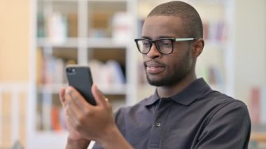 Akıllı telefon kullanan Pozitif Genç Afrikalı Adam Portresi