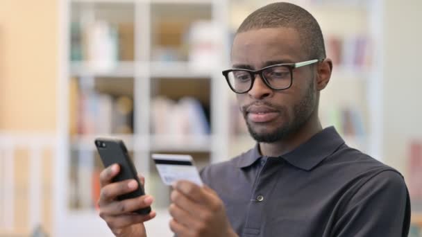 Retrato del joven africano haciendo pago en línea en Smartphone — Vídeo de stock