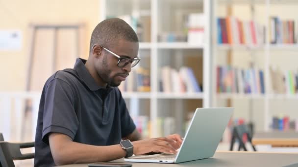 Un homme africain célèbre son succès sur un ordinateur portable à la bibliothèque — Video