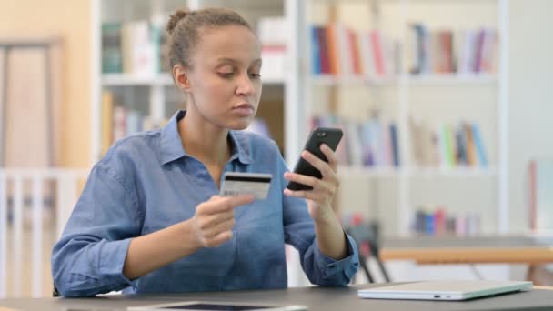 Exitoso pago en línea en Smartphone por mujer africana en la biblioteca — Vídeo de stock