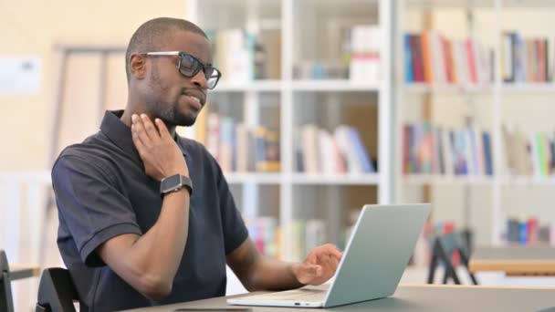 Fleißiger junger Afrikaner mit Laptop mit Nackenschmerzen in Bibliothek — Stockvideo