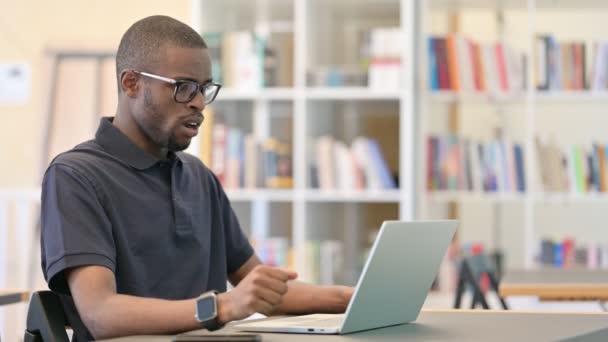 Bezorgd Jonge Afrikaanse Man met Laptop gevoel Geschokt op laptop — Stockvideo