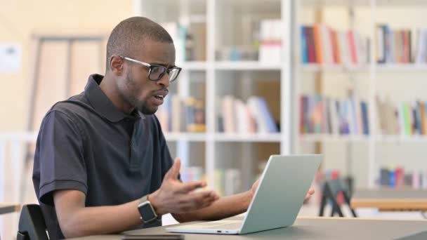 Schockierter junger Afrikaner reagiert auf Versagen in Bibliothek — Stockvideo