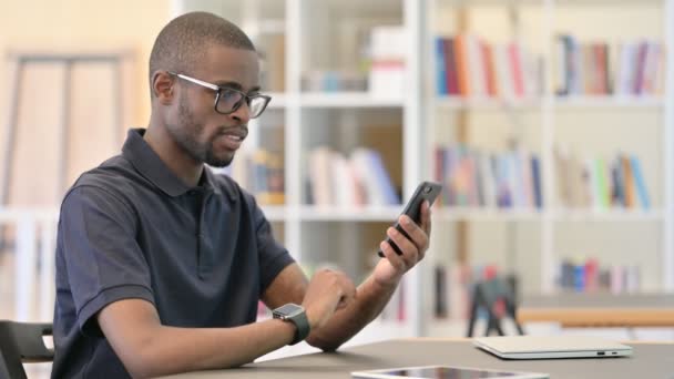 Ambicioso joven africano celebrando el éxito en el teléfono inteligente — Vídeos de Stock