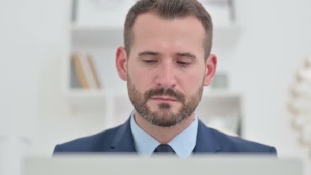 Retrato del atractivo hombre de negocios que trabaja en el ordenador portátil — Vídeo de stock