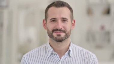 Kameraya gülümseyen mutlu genç adamın portresi 