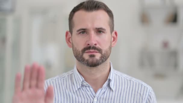 Portret poważnego młodego mężczyzny pokazuje znak stopu z ręki — Wideo stockowe