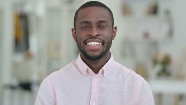 Portret van een vrolijke Afrikaanse man wijzend en uitnodigend — Stockvideo