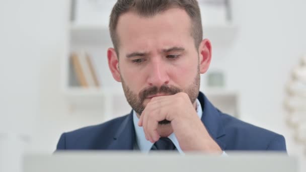 Portrét podnikatele přemýšlejícího a pracujícího na laptopu — Stock video