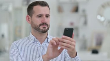 Akıllı telefon kullanan Pozitif Genç Adam Portresi 