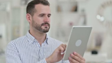 Dijital Tablet kullanan Hırslı Genç Adam Portresi