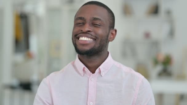 Portret van een glimlachende Afrikaanse man wijzend met vinger — Stockvideo