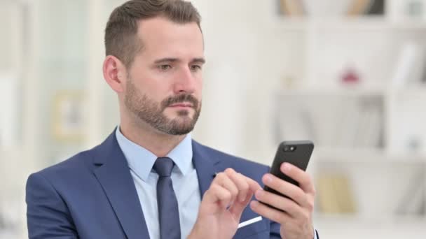Retrato de hombre de negocios enfocado usando teléfono inteligente — Vídeos de Stock