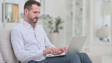 Genç Adam Bilgisayarı Kapatıyor ve Koltuktan Uzaklaşıyor