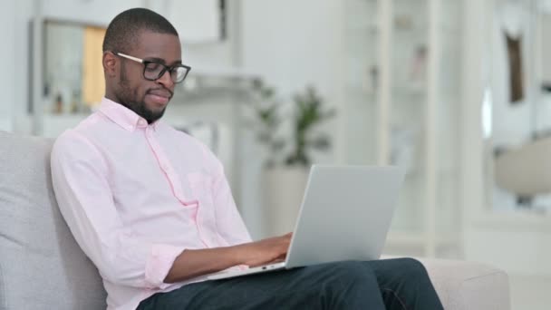 Hardwerkende jonge Afrikaanse man Werken op laptop thuis — Stockvideo