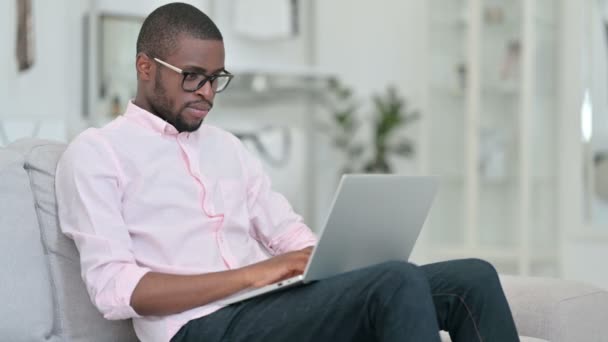 Pollici giù da uomo africano con computer portatile a casa — Video Stock