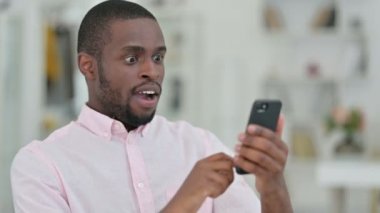 Akıllı telefonda başarıyı kutlayan Afrikalı Adam Portresi 