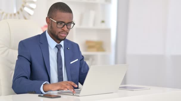 Aantrekkelijke Afrikaanse zakenman reageert op verlies op laptop in Office — Stockvideo