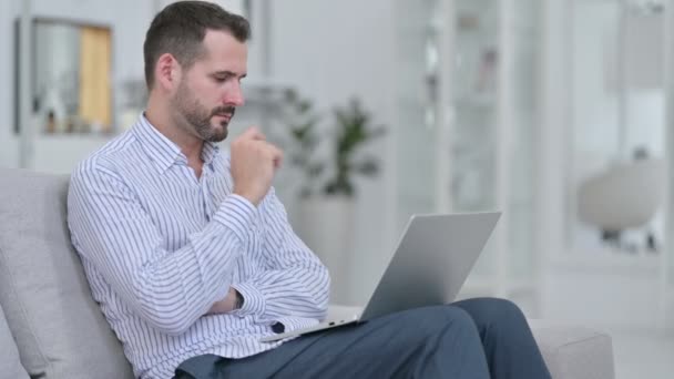 Hombre joven pensativo usando el ordenador portátil en casa — Vídeos de Stock