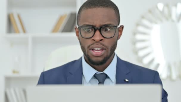 Retrato del empresario africano reaccionando a la pérdida en el ordenador portátil — Vídeos de Stock