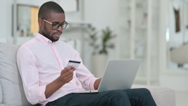 Pagamento on-line mal sucedido no laptop por homem africano em casa — Vídeo de Stock