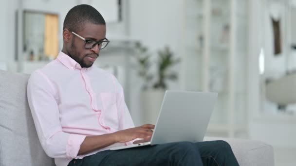 Homme africain épuisé avec ordinateur portable ayant mal au dos à la maison — Video
