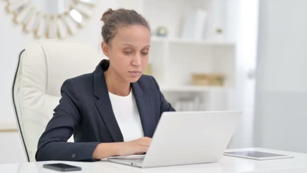 Gestresste afrikanische Geschäftsfrau mit Laptop hat Kopfschmerzen im Büro — Stockvideo