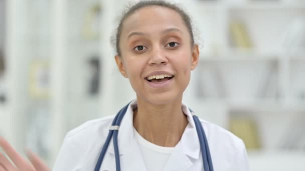 Retrato de amigable joven médico africano hablando en videollamada — Vídeos de Stock