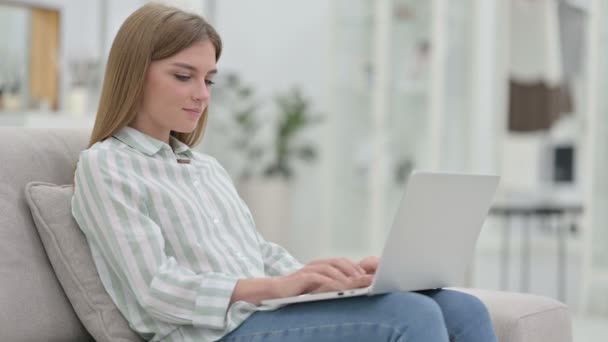 Mujer joven enfocada trabajando en el ordenador portátil en casa — Vídeos de Stock