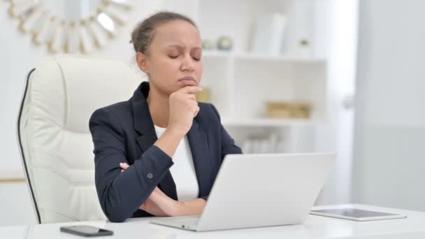 Pensive African Businesswoman Σκέψη και εργασία σε φορητό υπολογιστή στο γραφείο — Αρχείο Βίντεο