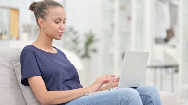 Mujer africana enfocada trabajando en el ordenador portátil en casa — Vídeo de stock