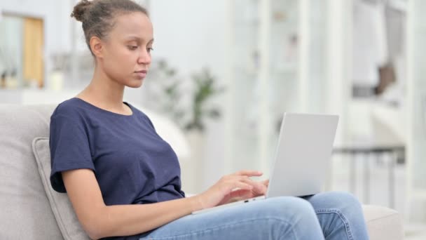 Perte, femme africaine réagissant à l'échec sur ordinateur portable à la maison — Video