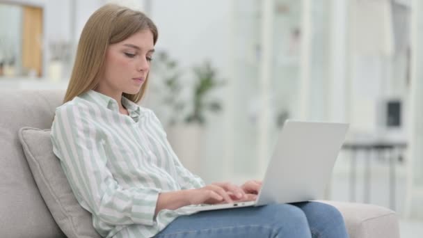 Dizüstü bilgisayarı olan yorgun genç bir kadın evde boyun ağrısı çekiyor. — Stok video