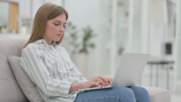 Κουρασμένη νεαρή γυναίκα με φορητό υπολογιστή που έχει πόνο στην πλάτη στο σπίτι — Αρχείο Βίντεο