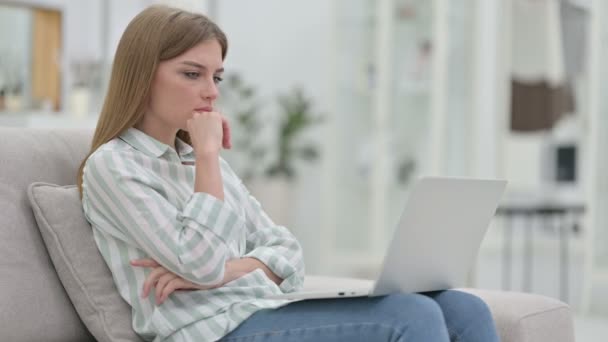 Umsichtige junge Frau denkt und arbeitet zu Hause am Laptop — Stockvideo