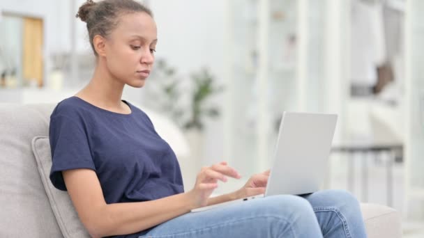 Mujer africana emocionada celebrando el éxito en el ordenador portátil en casa — Vídeo de stock