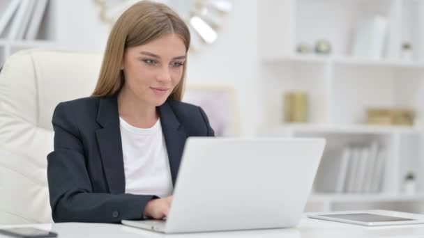 Femme d'affaires faisant appel vidéo sur ordinateur portable dans le bureau — Video