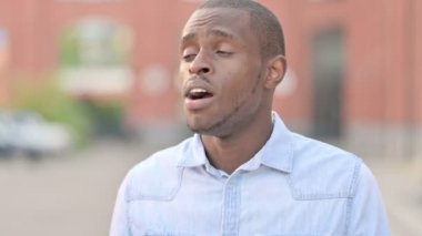 Bankta uyuyan yorgun Afrikalı adam.