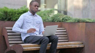 Laptop kullanan sırt ağrısı olan Afrikalı adam. 