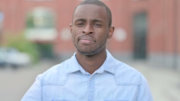 Retrato al aire libre del hombre africano decepcionado haciendo pulgares hacia abajo — Vídeos de Stock