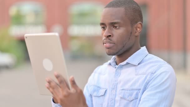 Retrato al aire libre del hombre africano decepcionado que tiene pérdida en la tableta — Vídeos de Stock