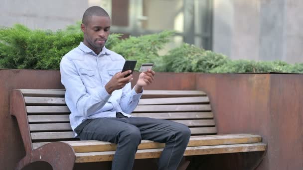 African Man Dokonywanie udanych płatności online na smartfonie — Wideo stockowe