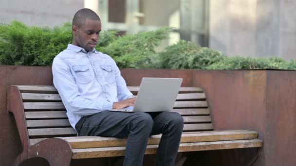 Sick Young African Man using Laptop Coughing Outdoor — Stock Video